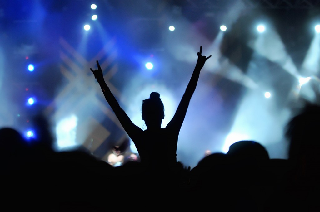 Silhouette of a girl with hand in the air on concert